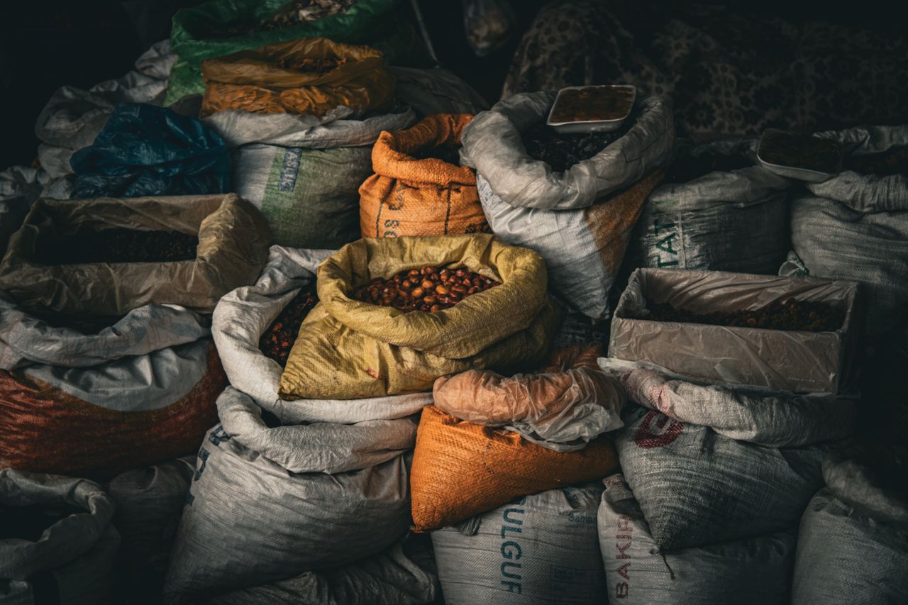 Home A variety of grains and spices in vividly colored sacks at an indoor market, providing rich textures.